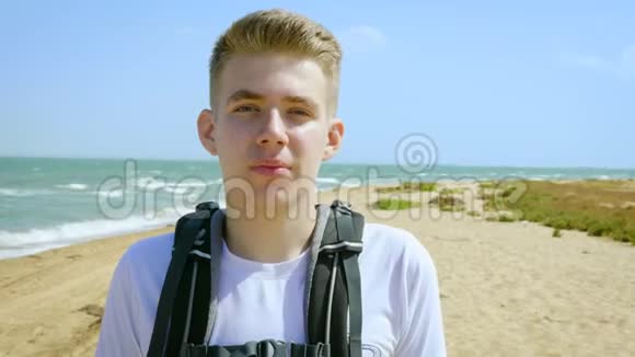一位年轻游客在海边沙滩上的肖像视频的预览图