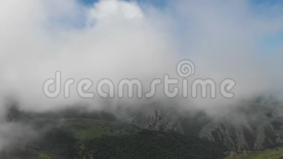 在阳光明媚的一天空中观看白天飞行在山上的云层和山丘上的概念视频的预览图