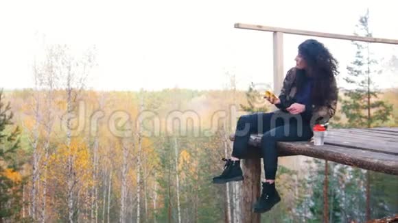 一个女人坐在高空平台上吃香蕉和喝水视频的预览图