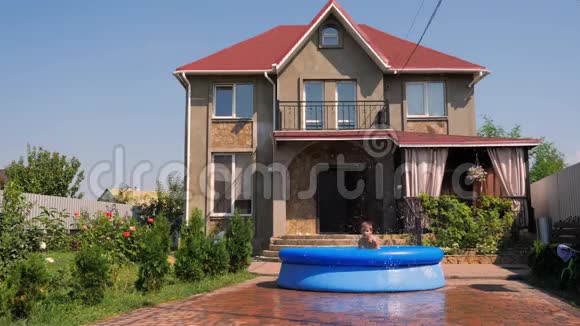 家后院的游泳池夏天一个男孩在乡下房子的后院里放松地玩水管视频的预览图