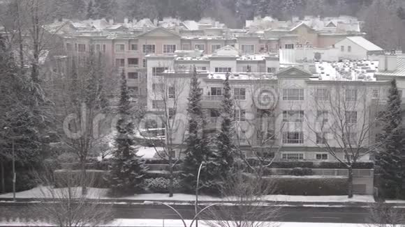 在寒冷的暴风雪中鸟瞰车流和低层公寓视频的预览图