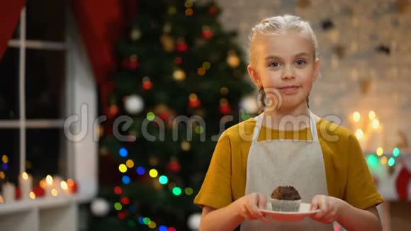 可爱的女孩在镜头前展示松饼微笑快乐的圣诞气氛视频的预览图