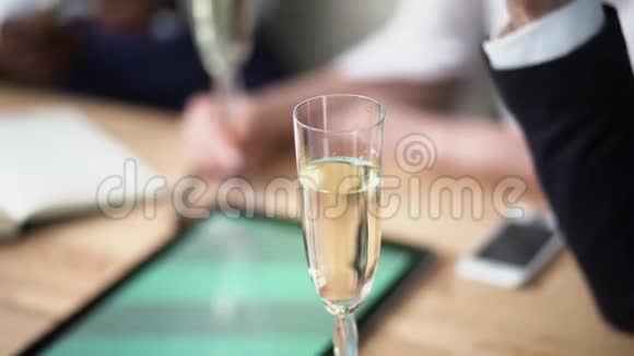 经过成功的谈判一家大公司的年轻经理正在办公室里喝香槟视频的预览图