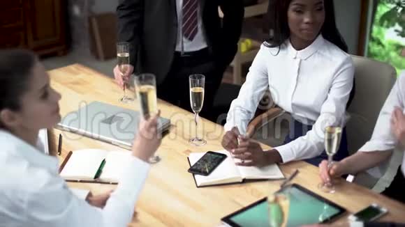 经过成功的谈判一家大公司的年轻经理正在办公室里喝香槟视频的预览图