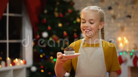 小幸福的女孩拿着盘子和巧克力松饼在假期前做准备视频的预览图