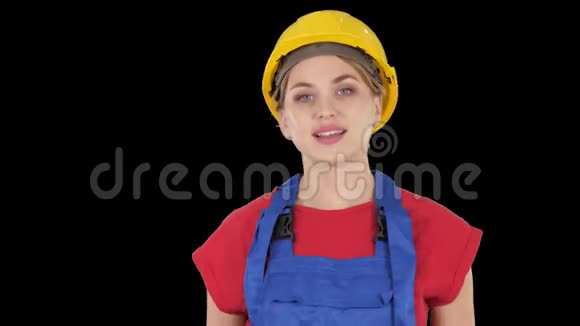 微笑的建筑工人妇女站立和改变姿势折叠手双手在臀部双手在口袋阿尔法频道视频的预览图