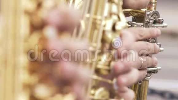 穿着夹克的萨克斯演奏家在金色萨克斯管上演奏现场表演爵士乐关注重点视频的预览图