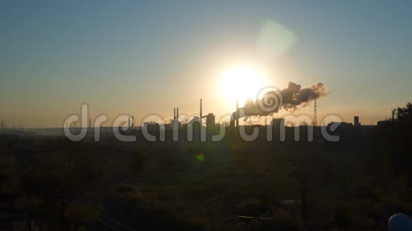 在日出的背景下工厂管道里冒出的烟雾视频的预览图