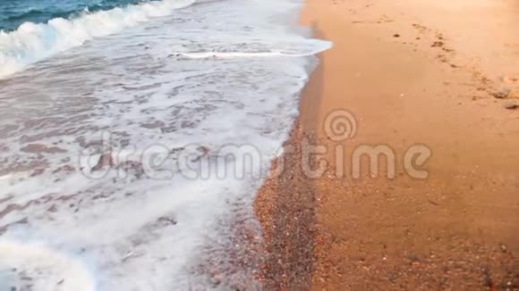 慢动作视频在金沙上沿着海浪行走视频的预览图