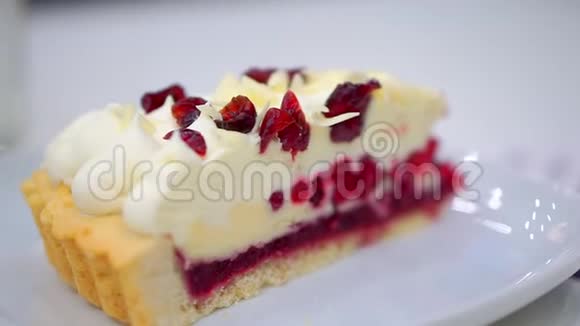在盘子里放一块加蔓越莓的芝士蛋糕它已经准备好吃了视频的预览图