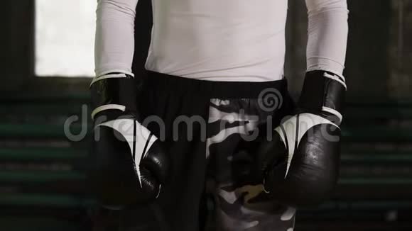 一个白人男性拳击手站在沙包附近的老式拳击馆的肖像穿着便服视频的预览图