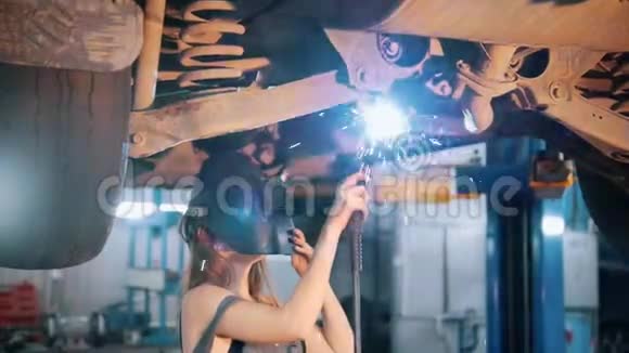 机械师女孩用电焊修理汽车并摘下头盔视频的预览图