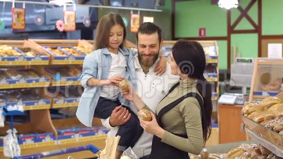 幸福的家庭和他们可爱的小女儿选择在超市烘焙视频的预览图