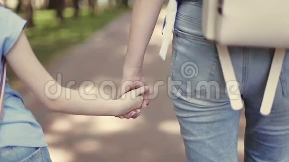 妈妈在公园散步时牵着小女儿的手视频的预览图