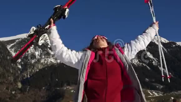 滑雪场的寒假雪坡背景下一位带着滑雪设备的年轻女子大声欢呼视频的预览图