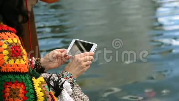 优雅的高级女性在智能手机上拍摄水的照片或视频视频的预览图