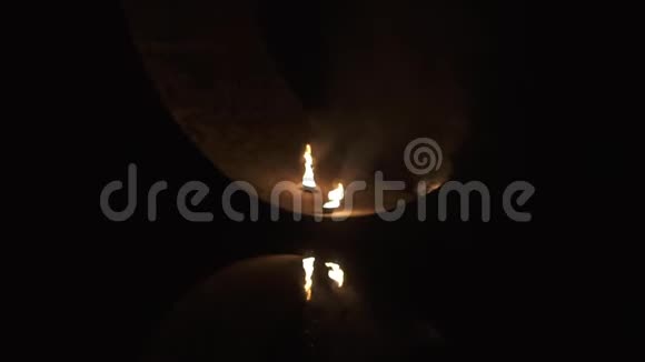 在靠近水面的桥下有火的碗会发光并在缓慢的运动中燃烧视频的预览图