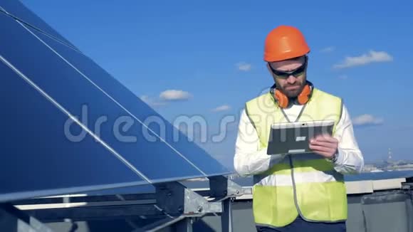 一个工人检查屋顶上的嵌板一位工程师检查太阳电池板的质量视频的预览图