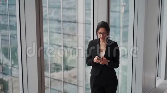 一位年轻的现代商务女性在玻璃和金属建筑背景下的肖像视频的预览图