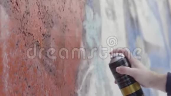 贴近艺术家绘画和在墙上喷涂油漆街头艺术理念行动男子双手侧视视频的预览图