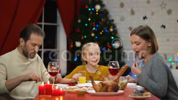 快乐的父母和女儿在圣诞前夕一起吃新鲜沙拉视频的预览图
