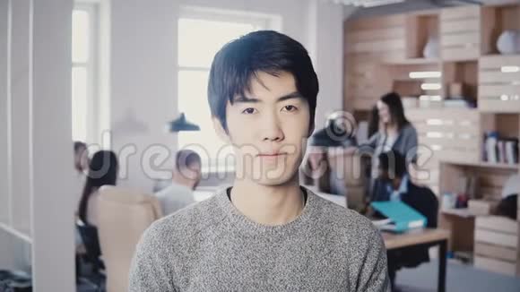 成功亚洲男性创业创始人摆姿势英俊的商人经理在繁忙的现代办公室4K看相机视频的预览图