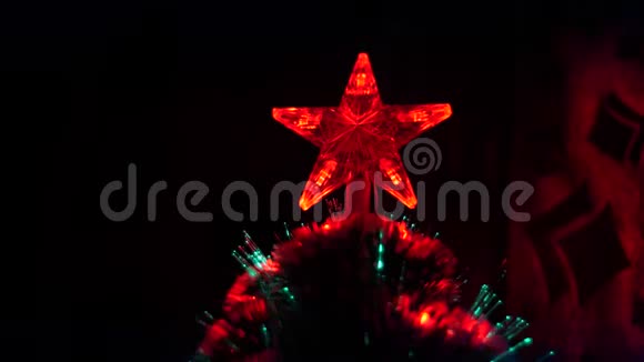 美丽的圣诞星在孩子们的房间里的圣诞树上闪烁彩灯视频的预览图