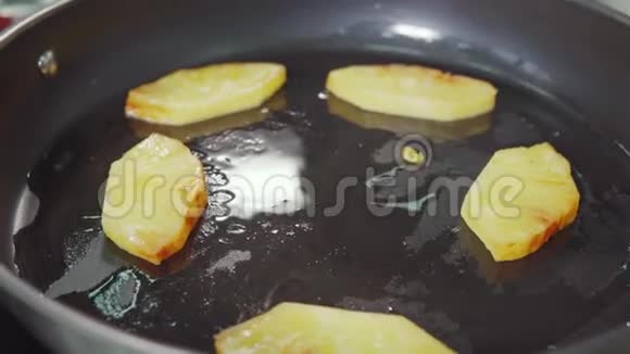 库克正在摇动锅菠萝片在油站在炊具特写视频的预览图