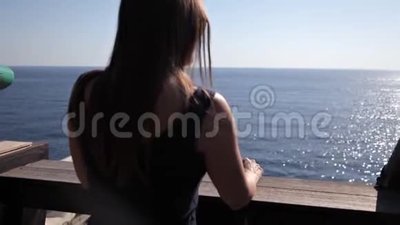 年轻女孩走在她房间的露台上可以看到海景视频的预览图