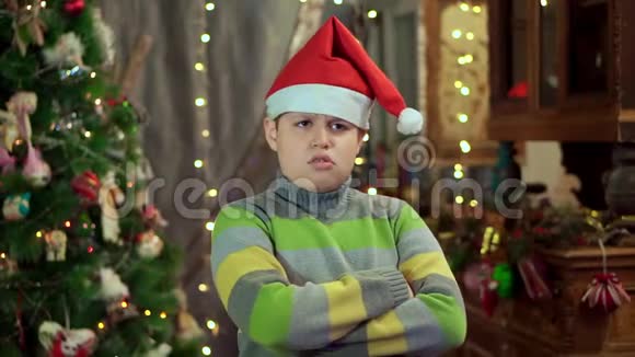 穿毛衣戴圣诞老人帽子的男孩生气了他没有天赋在视频的预览图