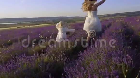 快乐而自由的母女俩正慢悠悠地奔跑在盛开的薰衣草地上视频的预览图