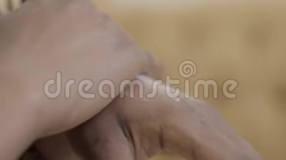 女性双手近距离摩擦非洲裔美国妇女在手上涂奶油护肤理念视频的预览图