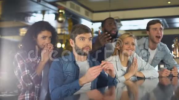 一群朋友在酒吧里看体育节目为输球而烦恼失败视频的预览图