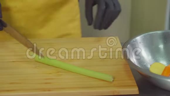厨师正在厨房的砧板上切芹菜梗然后放进碗里视频的预览图