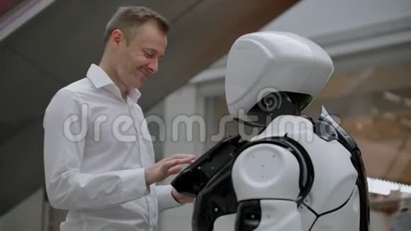 购物中心的那个人和一个机器人顾问沟通现代商店和机器人销售商机器人帮助一个男人视频的预览图