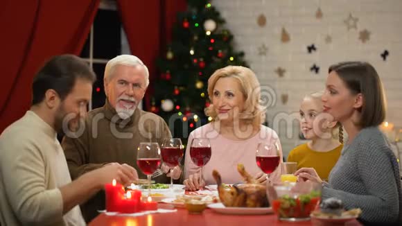 幸福的家庭一起享用美味健康的圣诞晚餐圣诞树上的灯光闪闪发光视频的预览图