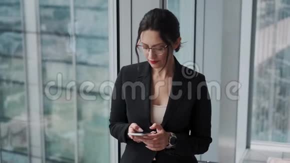 一位年轻的现代商务女性在玻璃和金属建筑背景下的肖像视频的预览图