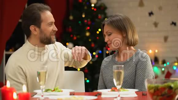 中年男子在圣诞前夜温柔地亲吻妻子爱着家庭关系视频的预览图