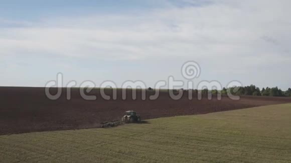 现代拖拉机的鸟瞰大棕色田野拖拉机对收获场的空中观察视频的预览图