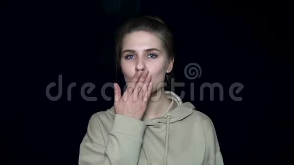 年轻女子送空气吻人的面部表情和情绪黑色孤立背景视频的预览图