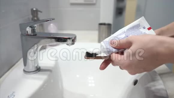 女人挤管把牙膏放在刷子上视频的预览图