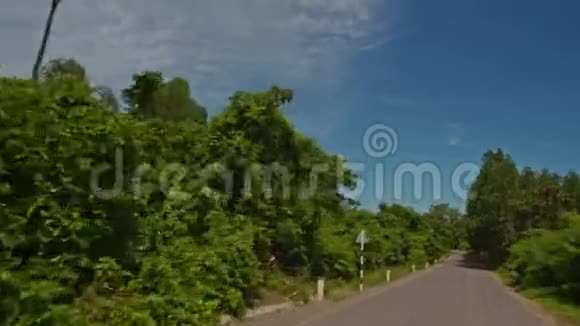 在越南的天空中摄像机沿着道路移动过去的树木田野视频的预览图