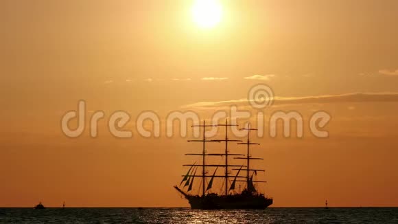 美丽的海上剪影帆船日落时分三艘船漂浮在公海上视频的预览图