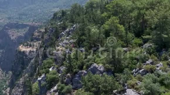 高高的岩石悬崖流入地中海全景几个游客视频的预览图