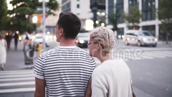 慢镜头微笑的西班牙年轻男子在纽约夏季大街上拥抱他的白种女友视频的预览图