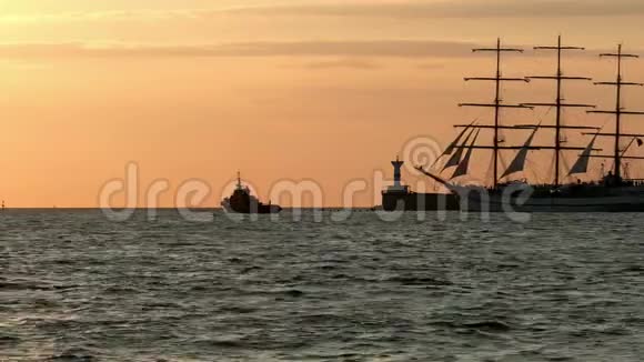 历史上高大的船复制品船帆船在一艘较小的拖船附近的海上灯塔旁漂浮视频的预览图