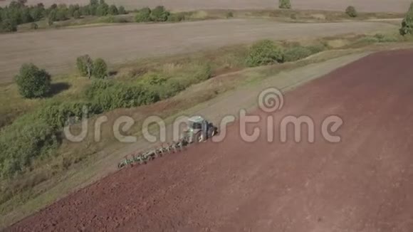 现代拖拉机的鸟瞰大棕色田野拖拉机对收获场的空中观察视频的预览图