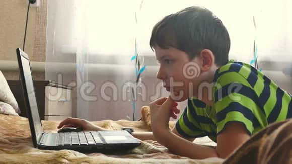男孩正在玩手提电脑浏览互联网视频的预览图