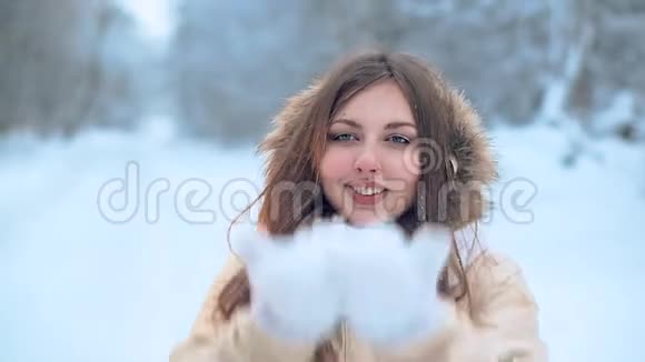 一个戴着白色围巾的年轻女孩在冬天的森林里散步视频的预览图