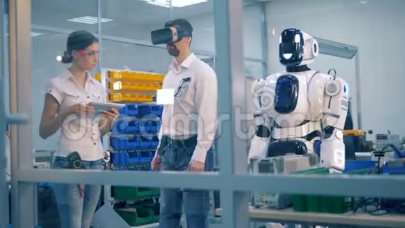 人类机器人正在模仿一名男性实验室工作人员在监督下的动作视频的预览图